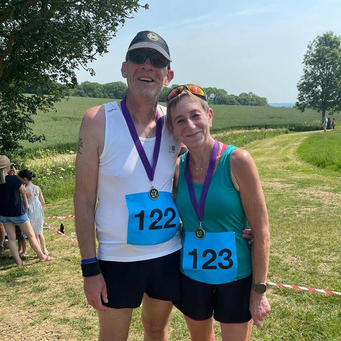 happy couple wearing medals for completing a running charity fundraiser