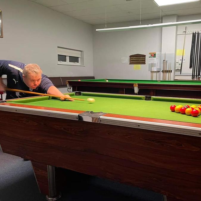 resident playing pool in charity fundraiser competition