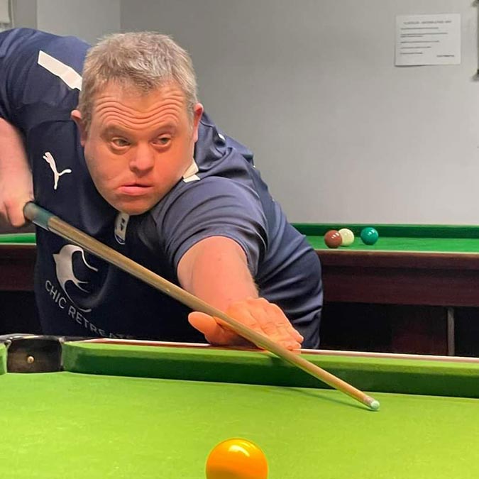 resident playing pool in charity fundraiser
