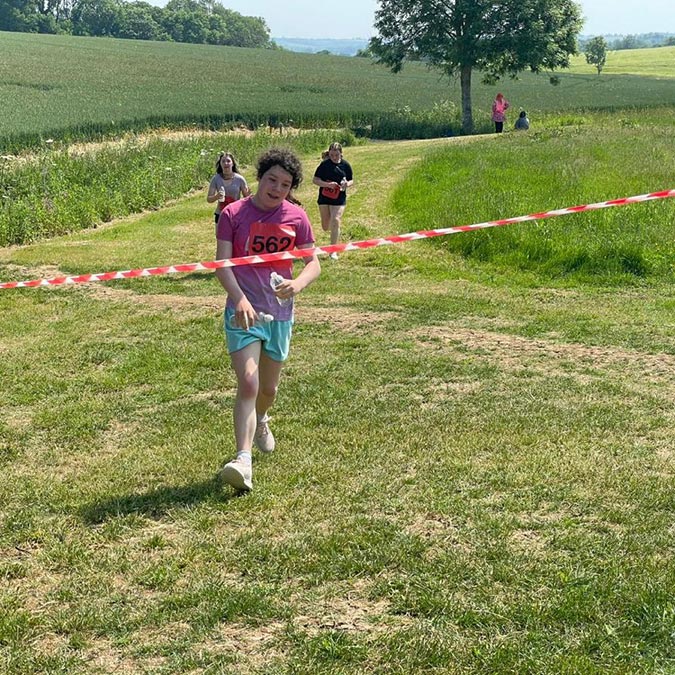 resident crossing the finish line running in charity fundraiser